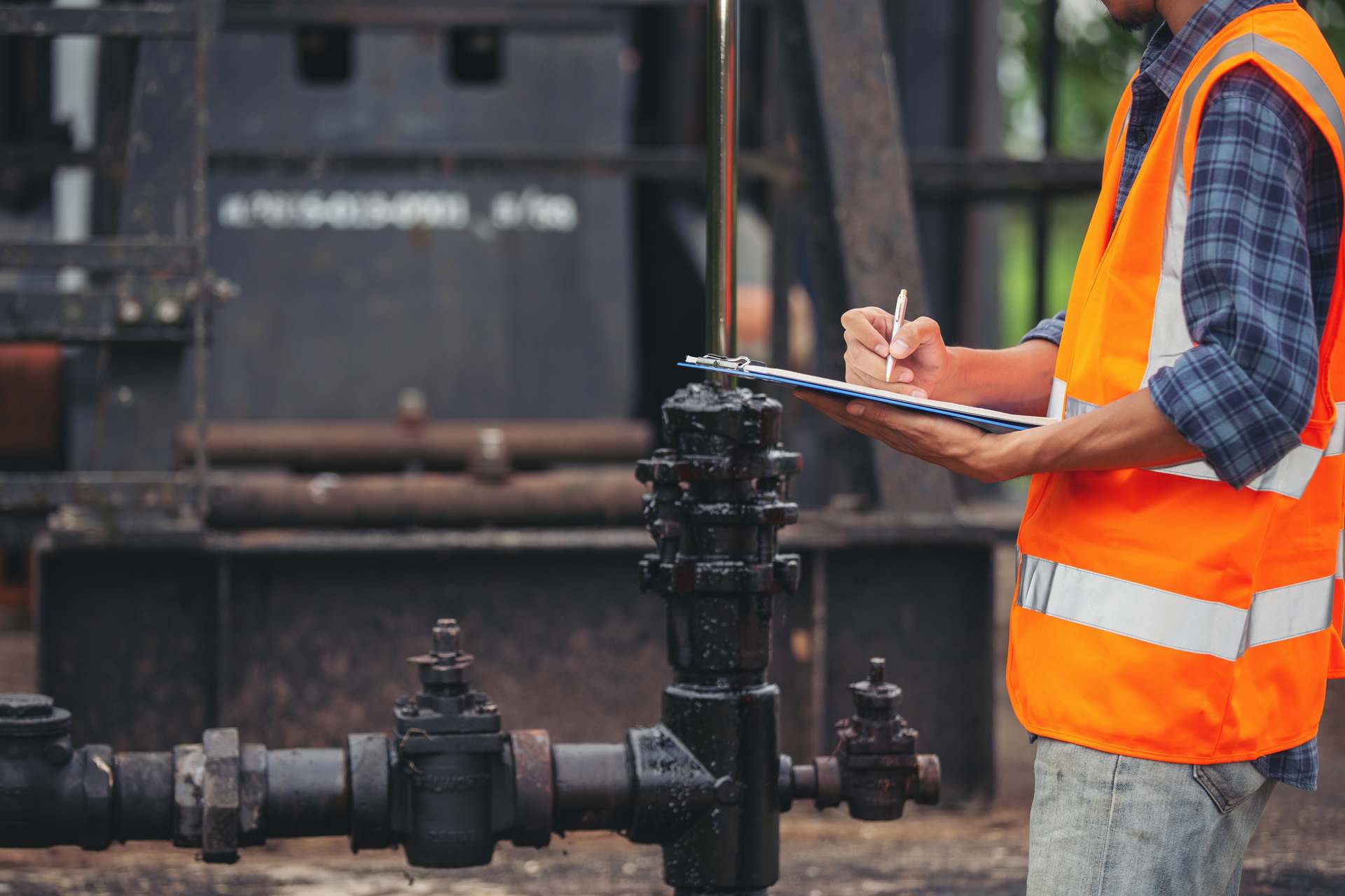 workers-standing-checking-beside-working-oil-pumps Inspection Team - 840 Inspections Inc.